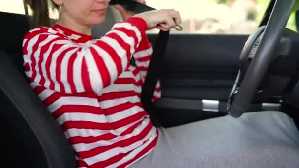 Donna che allaccia la cintura di sicurezza mentre è seduta all'interno del veicolo prima della guida — Video Stock