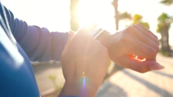 Smartwatch. Femme utilisant une montre intelligente. Gros plan de l'écran tactile tactile féminin sur la montre entrant dans l'application de montre et commence à courir — Video