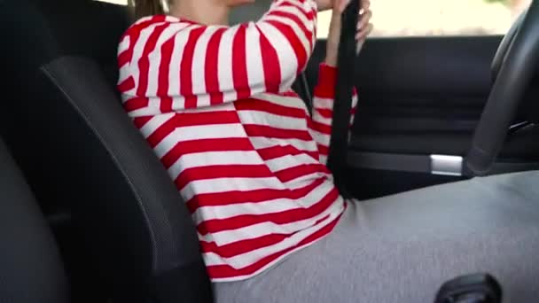 Woman fastening car safety seat belt while sitting inside of vehicle before driving — Stock Video