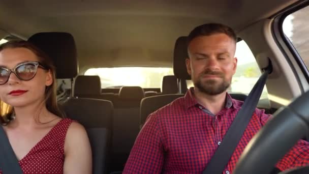 Mutlu çift bir arabaya biner, çevredeki manzaralara hayran kalır ve birbirlerine gülümser — Stok video