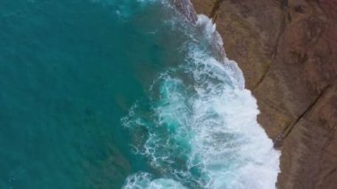 Atlas Okyanusu'ndaki çöl taşlı sahilinin en iyi manzarası. Tenerife adasının sahili. Kıyıya ulaşan deniz dalgalarının havadan drone görüntüleri