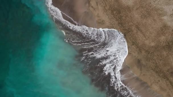 Vista superior da praia do deserto no Oceano Atlântico. Costa da ilha de Tenerife. Imagens aéreas de drones de ondas marinhas que chegam à costa — Vídeo de Stock