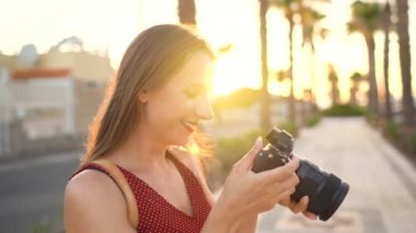 Fotoğrafçı turist kadın gün batımında güzel bir tropikal manzara kamera ile fotoğraf çekmek