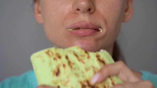 Mujer comiendo shawarma de espinacas con pollo y verduras de cerca — Vídeo de stock