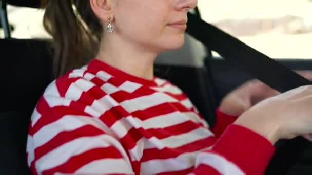 Kvinna infästning bil säkerhet säkerhetsbältet när du sitter inne i fordonet innan körning — Stockvideo