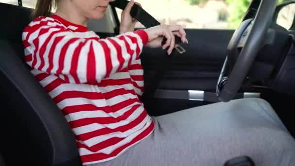 Femme attachant la ceinture de sécurité de la voiture tout en étant assis à l'intérieur du véhicule avant de conduire — Video