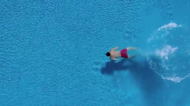 Vista dall'alto mentre un uomo si tuffa nella piscina e nuota sott'acqua — Video Stock