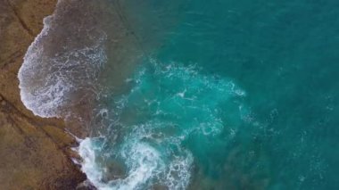 Atlas Okyanusu'ndaki çöl taşlı sahilinin en iyi manzarası. Tenerife adasının sahili. Kıyıya ulaşan deniz dalgalarının havadan drone görüntüleri