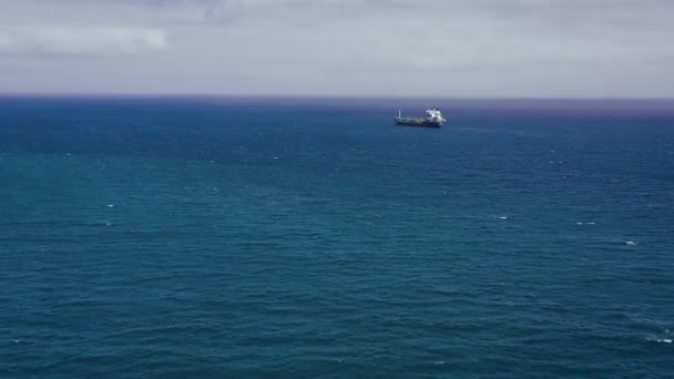 Vista a partir da altura em um navio de mar para o transporte de um navio de carga seca com um porão fechado está ancorado perto da cidade portuária e aguarda descarregamento. Importação e exportação por mar — Vídeo de Stock