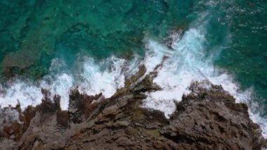 Issız bir sahilin en iyi manzarası. Tenerife adasının kayalık kıyısı. Kıyıya ulaşan okyanus dalgalarının havadan drone görüntüleri