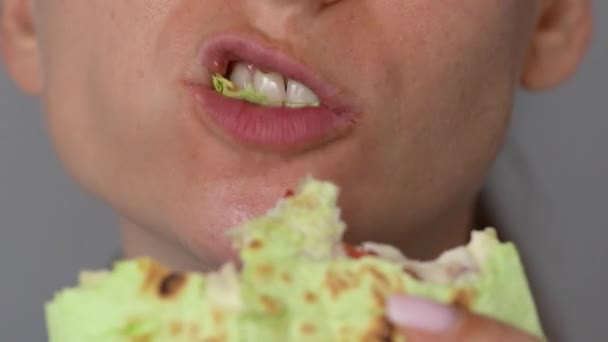Mujer comiendo shawarma de espinacas con pollo y verduras de cerca — Vídeo de stock