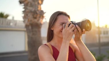 Fotoğrafçı turist kadın gün batımında güzel bir tropikal manzara kamera ile fotoğraf çekmek