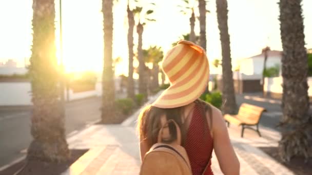 Fotógrafa turista con un gran sombrero amarillo tomando fotos con cámara en un hermoso paisaje tropical al atardecer — Vídeos de Stock