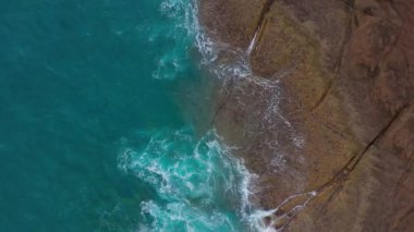 Atlas Okyanusu'ndaki çöl taşlı sahilinin en iyi manzarası. Tenerife adasının sahili. Kıyıya ulaşan deniz dalgalarının havadan drone görüntüleri