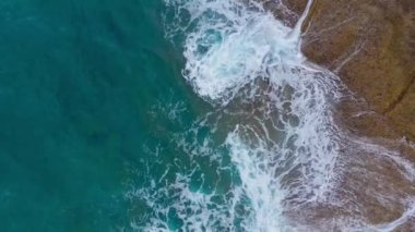 Atlas Okyanusu'ndaki çöl taşlı sahilinin en iyi manzarası. Tenerife adasının sahili. Kıyıya ulaşan deniz dalgalarının havadan drone görüntüleri