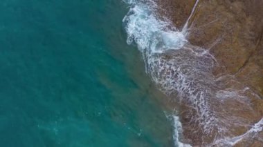 Atlas Okyanusu'ndaki çöl taşlı sahilinin en iyi manzarası. Tenerife adasının sahili. Kıyıya ulaşan deniz dalgalarının havadan drone görüntüleri