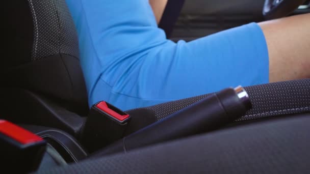 Woman in blue dress fastening car safety seat belt while sitting inside of vehicle before driving — Stock Video