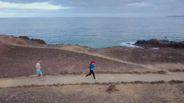 Vue aérienne de l'homme et de la femme courant le long de la réserve naturelle au lever du soleil. Mode de vie sain et actif — Video