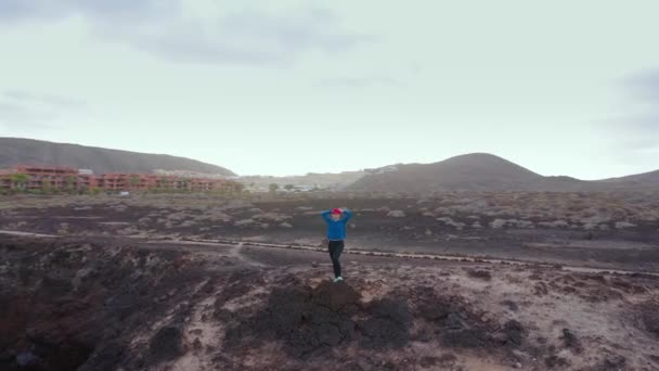 Aerial view of woman stands on top of a rock and enjoys the scenery in a conservation area on the shores of the Atlantic Ocean. Tenerife, Canary Islands, Spain — Stock Video