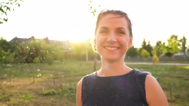 Porträt einer hübschen Frau an einem sonnigen Tag im Freien. Flaum aus Schilf fliegt herum — Stockvideo