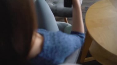 Kadın bir sandalyede oturuyor, yeşil ekran ile Tv izliyor, uzaktan kumanda ile kanal geçiş. Renk anahtarı. Kapalı