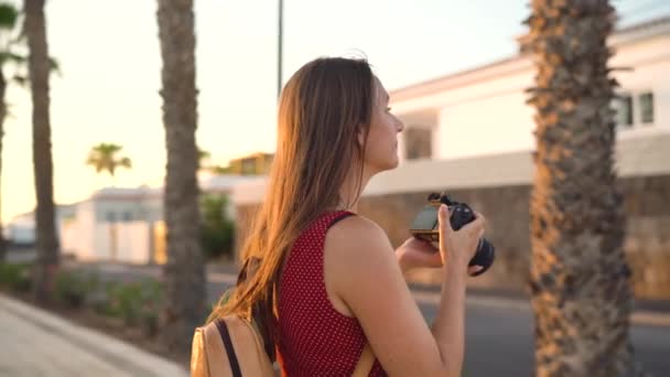 Fotógrafa turista tomando fotos con cámara en un hermoso paisaje tropical al atardecer — Vídeos de Stock