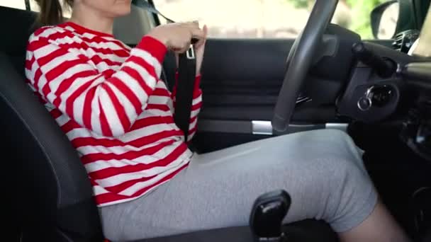 Жінка кріпиться ремінь безпеки автомобіля, сидячи всередині транспортного засобу перед водінням — стокове відео