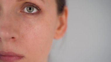 Covid-19 koronavirüsünün pandemik koruması. Tıbbi maske takan beyaz bir kadın. Virüs koruması. Çerçevede yarı yüz ve kopyalama alanı