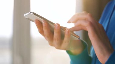 Batan güneşe karşı akıllı telefon kullanan kadın eller..