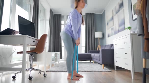 Mujer caucásica entrena piernas y nalgas en casa durante la cuarentena debido a COVID-19 — Vídeos de Stock