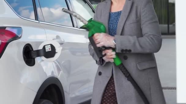Woman fills petrol into her car at a gas station close-up — Stock Video