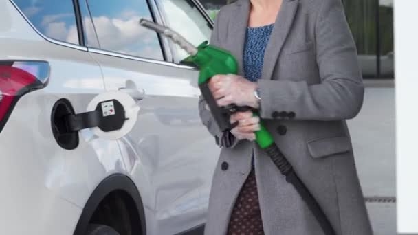 Mujer llena gasolina en su coche en una gasolinera de cerca — Vídeo de stock