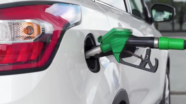 El coche está repostando en la gasolinera, el cañón de repostaje en el tanque de combustible — Vídeo de stock