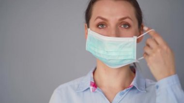 Covid-19 koronavirüsünün pandemik koruması. Tıbbi maske takan beyaz bir kadın. Virüs koruması.