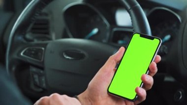 Sürücü arabanın içinde akıllı telefon kullanıyor. Yeşil ekranlı Chromakey akıllı telefon. Otomatik navigasyon. İnternet bağımlılığı