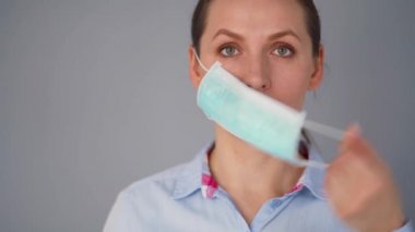 Covid-19 koronavirüsünün pandemik koruması. Tıbbi maske takan beyaz bir kadın. Virüs koruması.