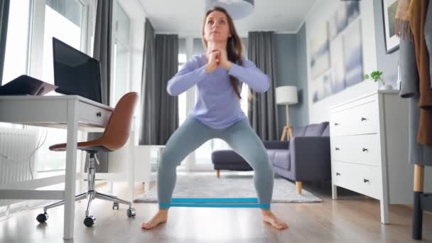 Blanke vrouw traint thuis benen en billen tijdens quarantaine en zelfisolatie thuis — Stockvideo