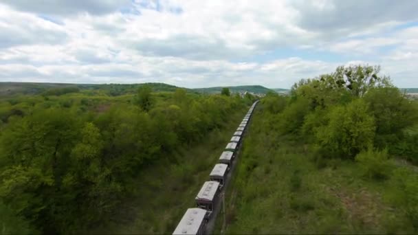 FPV drone letí rychle a obratně v blízkosti jedoucího nákladního vlaku — Stock video