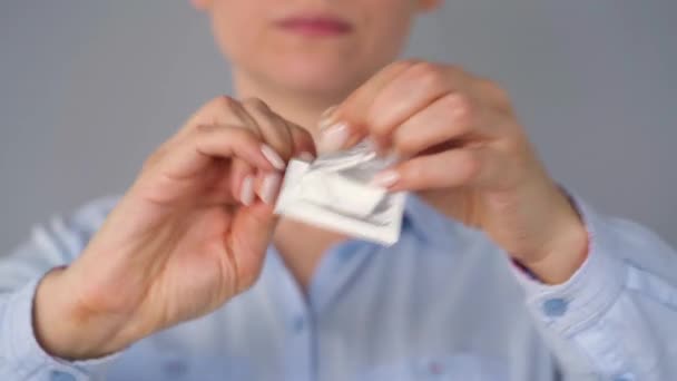 카메라 앞에서 콘돔을 보여 주는 여성 손, 안전 한 섹스, 피임 — 비디오