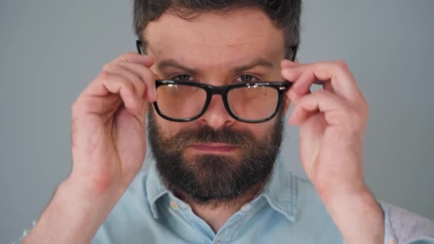 Retrato de un guapo barbudo se pone las gafas y se retuerce el bigote — Vídeos de Stock