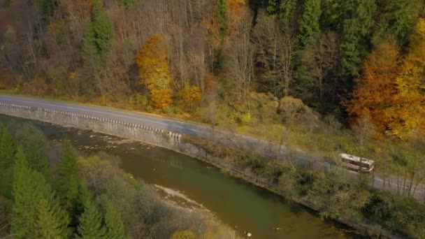 Vista dall'alto sul paesaggio autunnale - fiume, foresta su un fianco della montagna, auto sulla strada — Video Stock