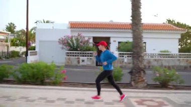 Kadın caddede koşuyor. Sağlıklı aktif yaşam tarzı. Yan görünüm