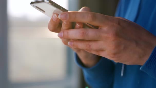 Ženské ruce pomocí smartphonu proti zapadajícímu slunci. — Stock video