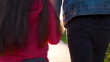 Baba ve kızı gün batımında kendi bölgelerinde dolaşırlar. Çocuk babasının elini tutuyor. Yavaş çekim