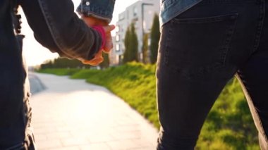 Baba ve kızı gün batımında kendi bölgelerinde dolaşırlar. Çocuk babasının elini tutuyor. Yavaş çekim