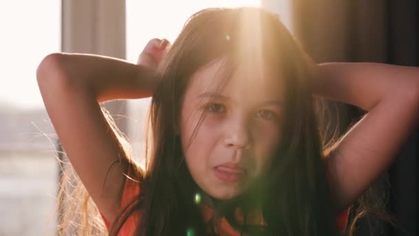 Portret brunetki na tle zachodzącego słońca. Piękne dziecko patrzące w kamerę, śmiejące się i robiące miny — Wideo stockowe