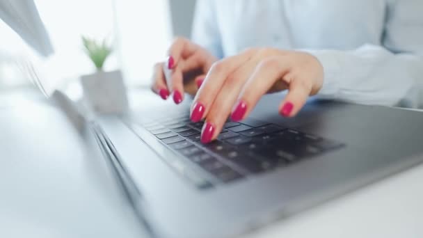 Női kezek fényes manikűrrel gépeléssel egy laptop billentyűzetén. A távmunka fogalma. — Stock videók