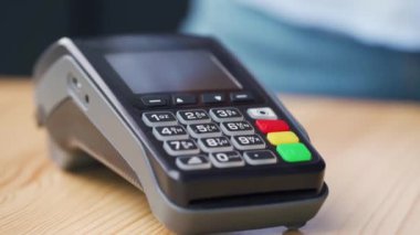 Akıllı telefonunla temassız ödeme. Kablosuz ödeme konsepti. Yakın plan, kadın banka terminalindeki siparişi ödemek için akıllı telefon nakitsiz cüzdan teknolojisi kullanıyor..