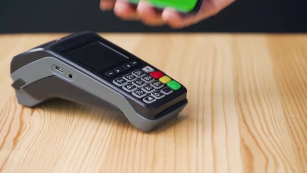 Kontaktloses Bezahlen mit dem Smartphone mit grünem Bildschirm. Wireless Payment Konzept. Nahaufnahme: Frau nutzt Smartphone-NFC-Technologie für bargeldlosen Geldbeutel, um am Bankterminal zu bezahlen. — Stockvideo