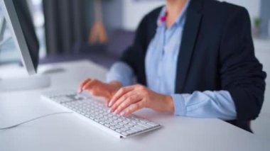 Gözlüklü bir kadın bilgisayar klavyesinde daktilo kullanıyor. Uzak çalışma kavramı.